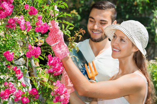 Worker wearing PPE operating a hedge cutter